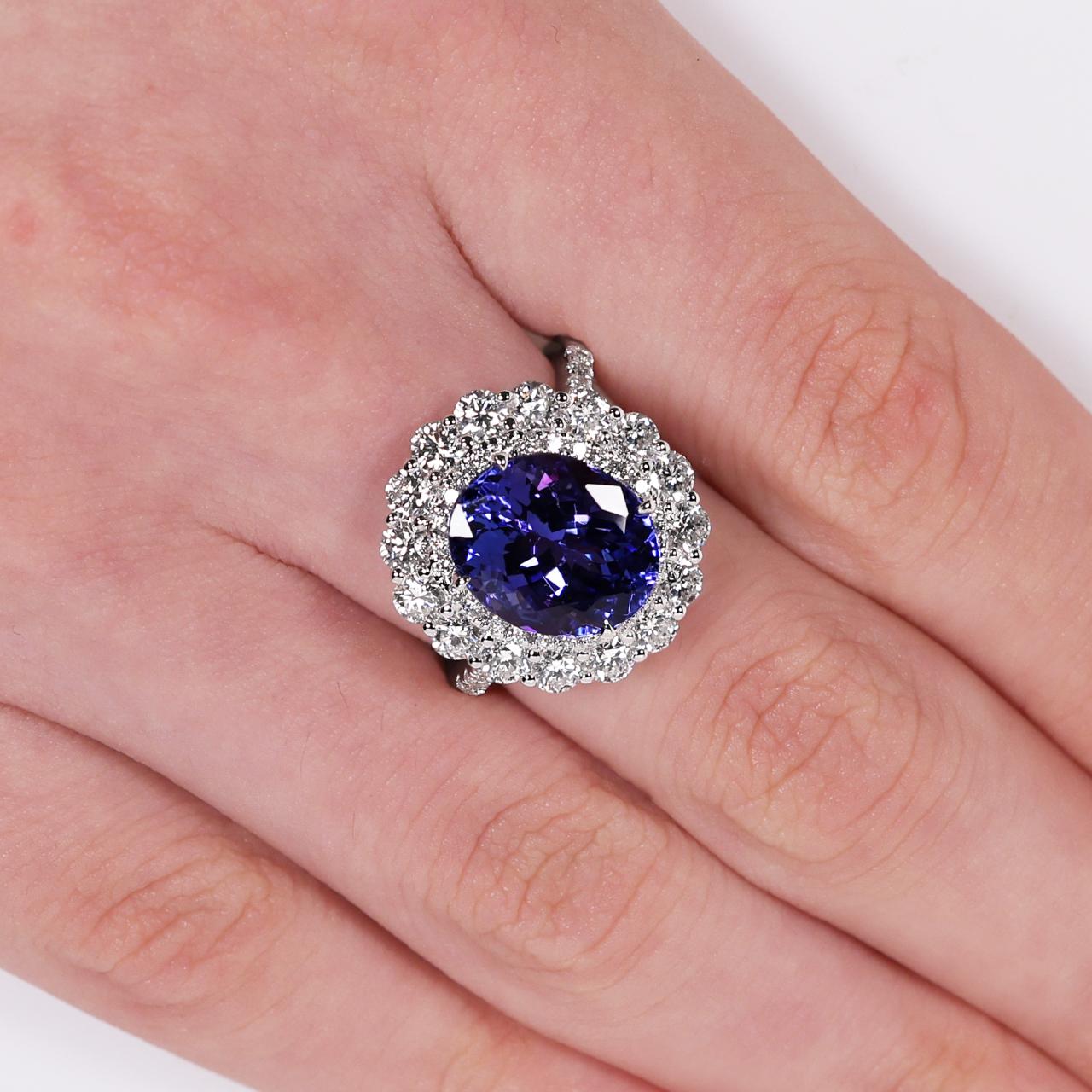 18ct white gold tanzanite and round brilliant cut diamond claw set double halo ring on the finger