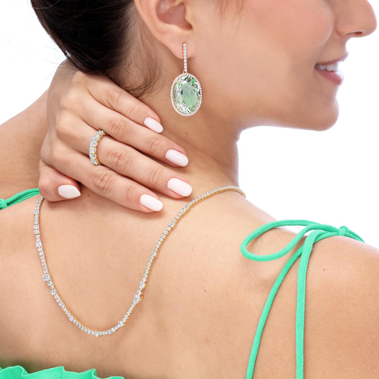 A pair of 18ct rose gold oval green amethyst and diamond drop earrings on the ear