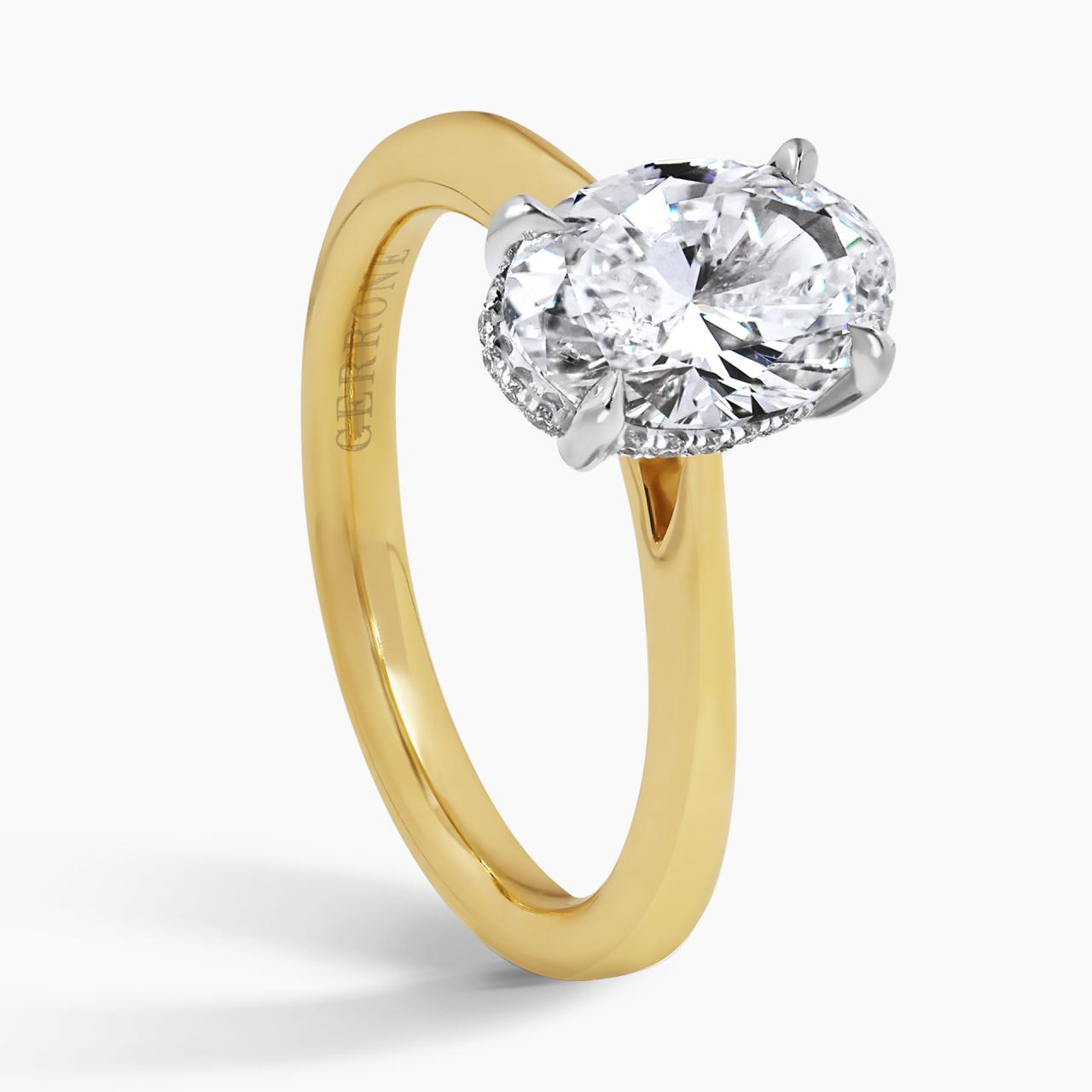 18ct yellow and white gold oval brilliant cut diamond ring in a four claw setting with hidden halo