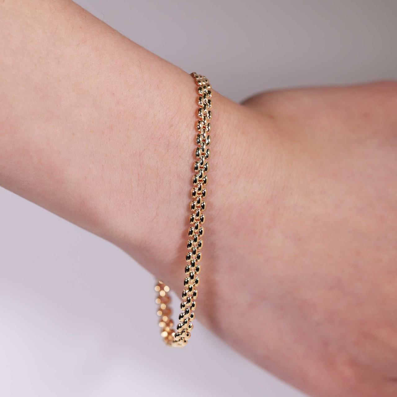 18ct yellow gold brick link bracelet with lobster clasp worn on the wrist