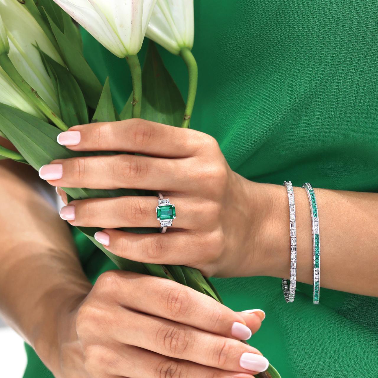 18ct white gold cushion cut Colombian Emerald and Cadillac diamond ring on the finger