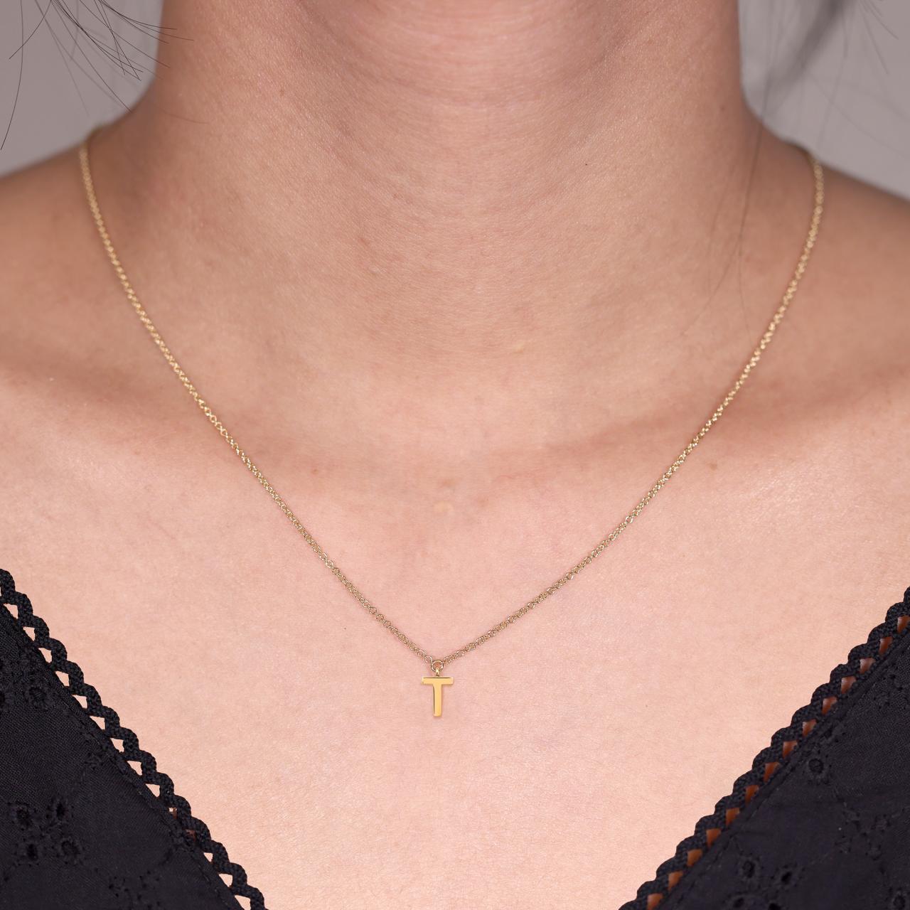 18ct yellow gold initial "T" necklace on the neck