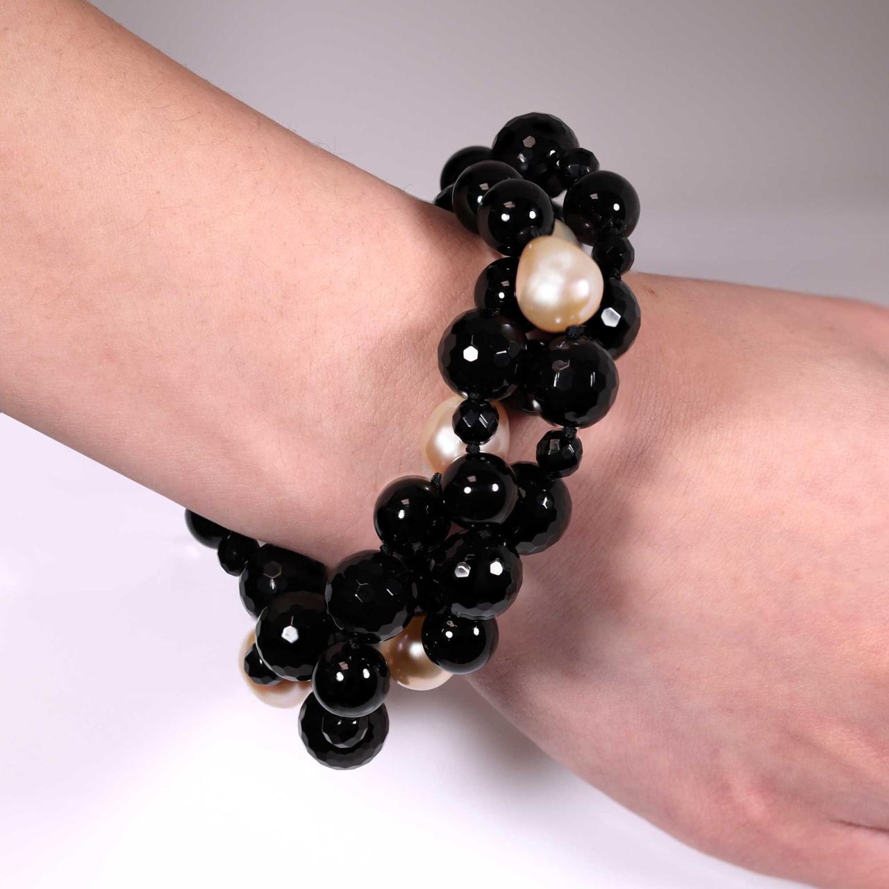 Three rows of apricot fresh water pearl and onyx beads bracelet ended with a silver ribbed magnetic clasp on the wrist