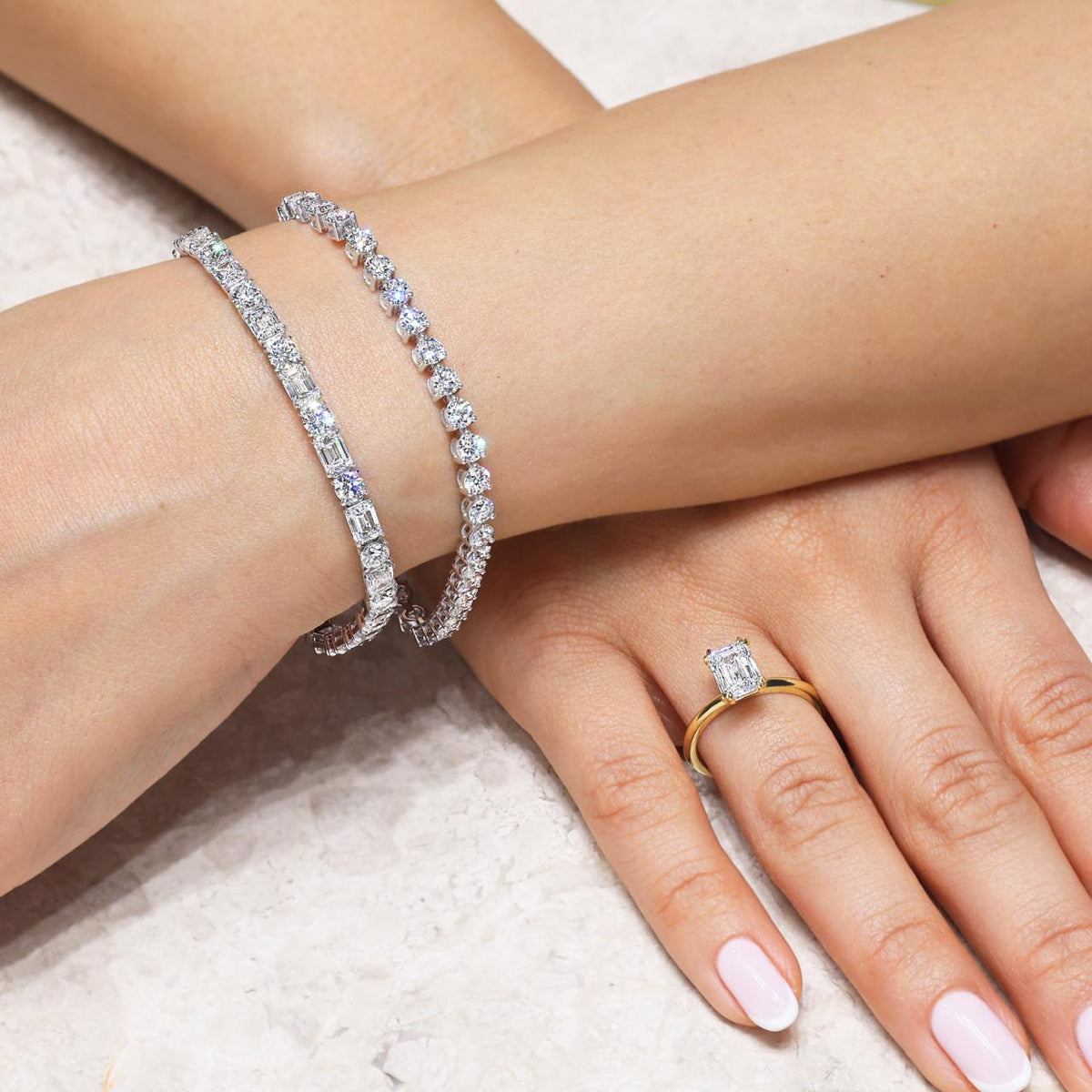 18ct white gold emerald and round brilliant cut diamonds tennis bracelet in a four claw setting on the wrist