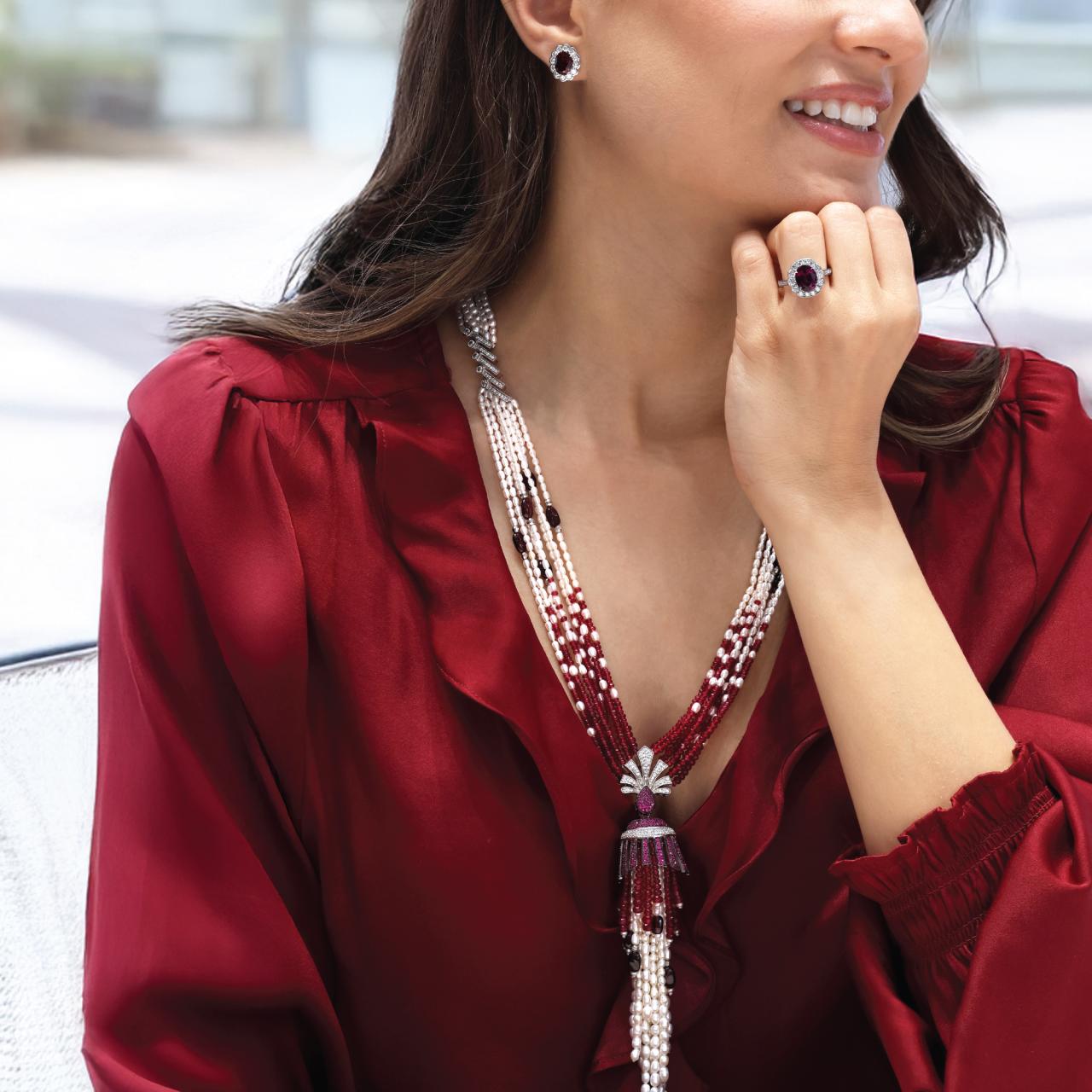 Fresh water pearl, red garnet, red agate beads tassel necklace with silver cubic zirconia clasp displayed on the neck