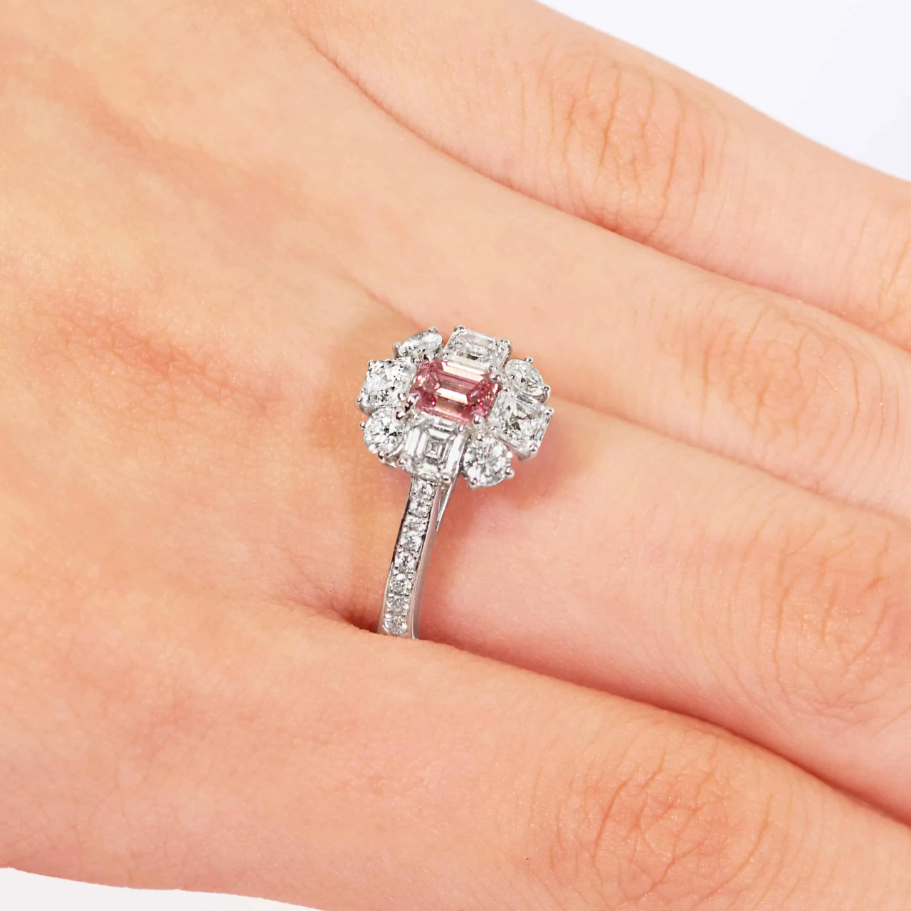 Platinum fancy intense purplish pink diamond, carre and round brilliant cut white diamond halo ring on finger