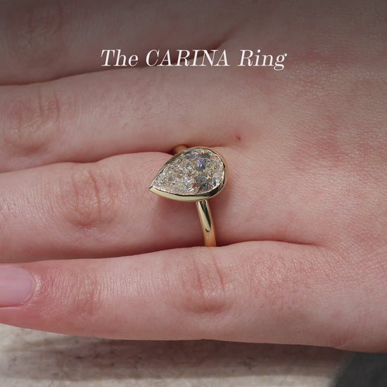 18ct yellow gold pear shaped LAB Grown Diamond bezel set solitaire ring on finger