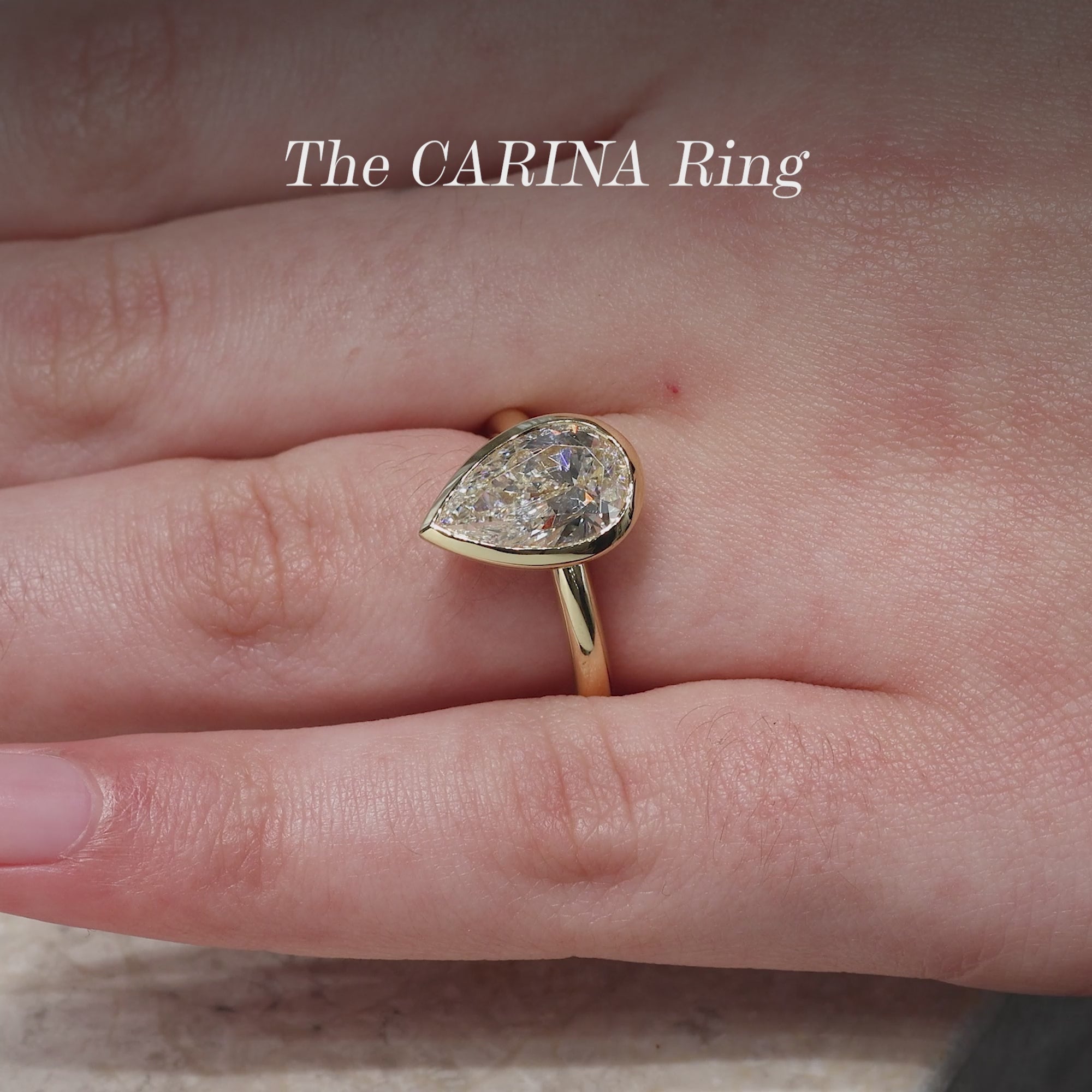 18ct yellow gold pear shaped LAB Grown Diamond bezel set solitaire ring on finger