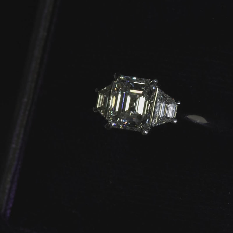 Platinum emerald cut and trapezoid step cut diamond ring