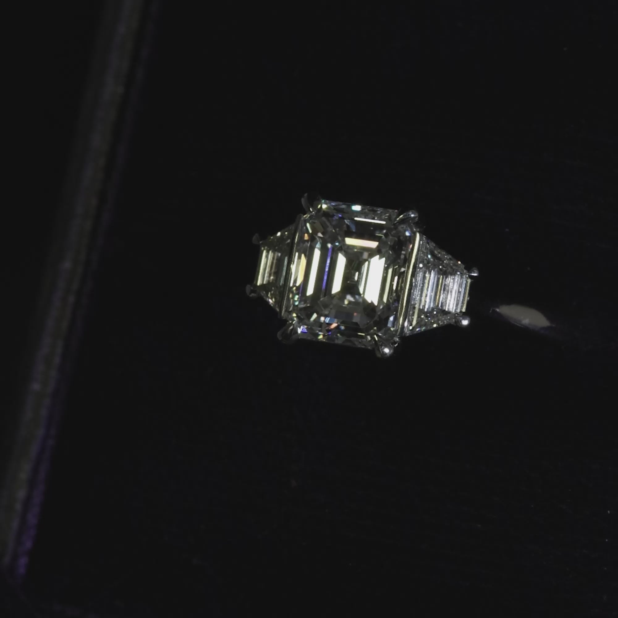 Platinum emerald cut and trapezoid step cut diamond ring