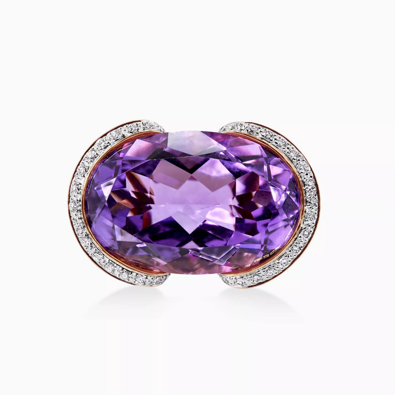 An 18ct rose gold ring with an oval amethyst centerpiece, surrounded by round brilliant cut diamonds and pink sapphires.