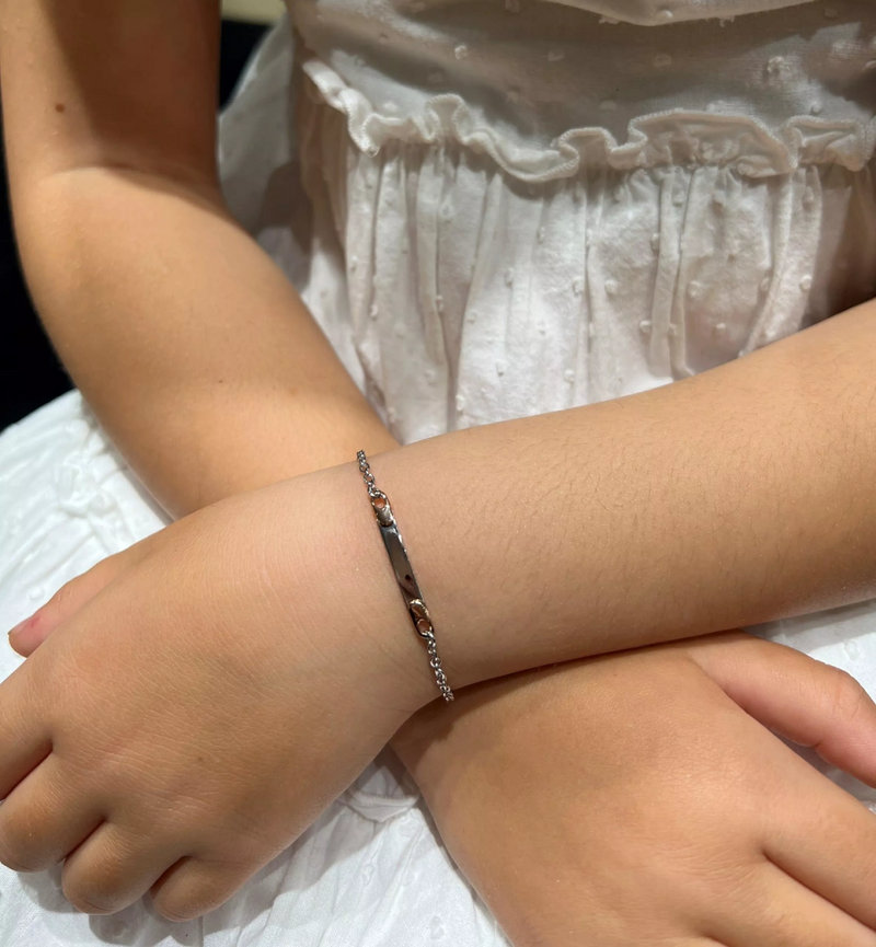 18ct white and rose gold ID tag baby bracelet on child's wrist
