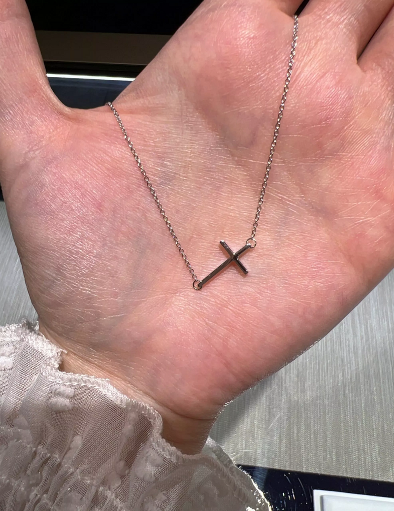 18ct white gold cross necklace on the hand to display size of cross