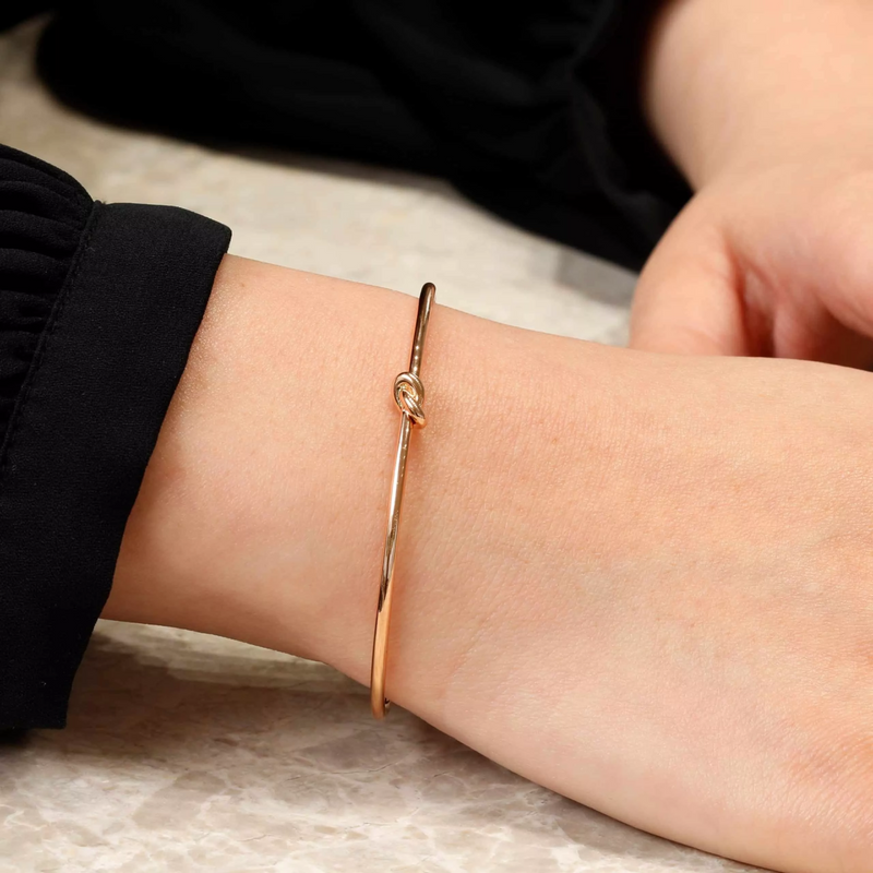 18ct rose gold knot bangle on the wrist