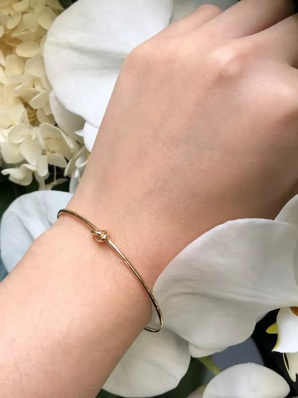 18ct yellow gold knot bangle on the wrist