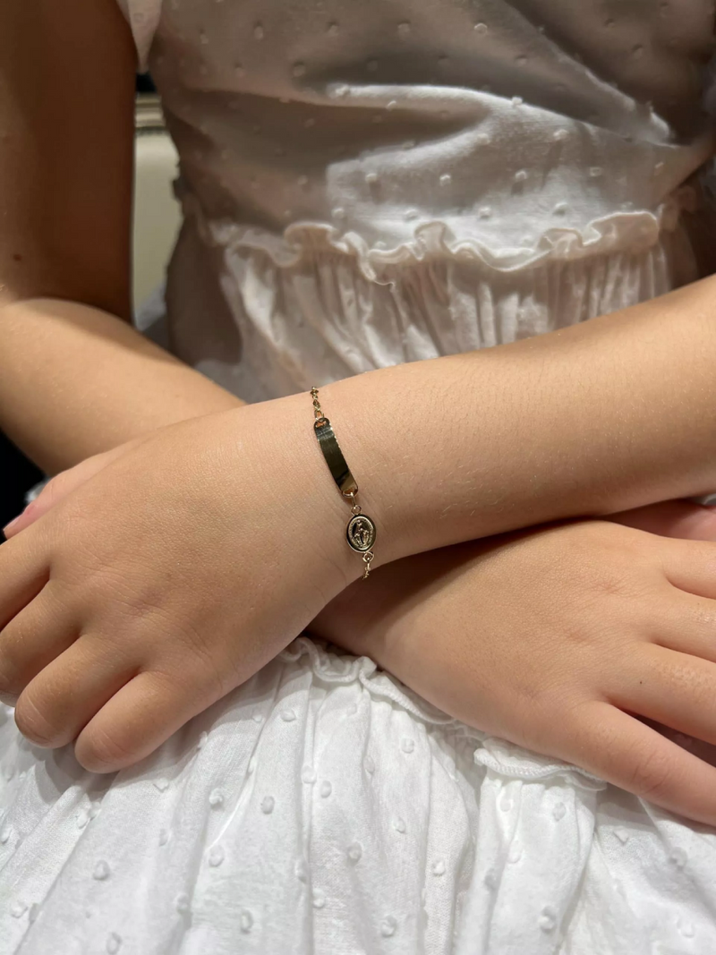 18ct yellow gold baby ID bracelet with religious medal on the wrist