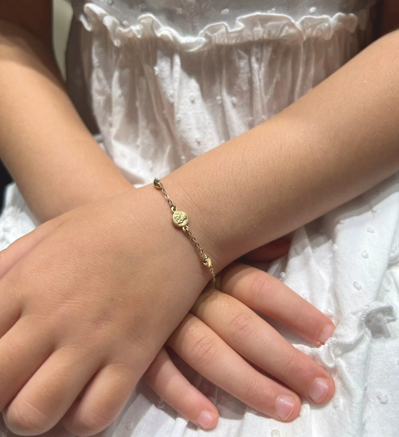 18ct yellow gold baby bracelet with an angel medal on child's wrist