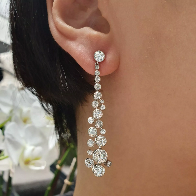 Platinum diamond drop earrings on the ear