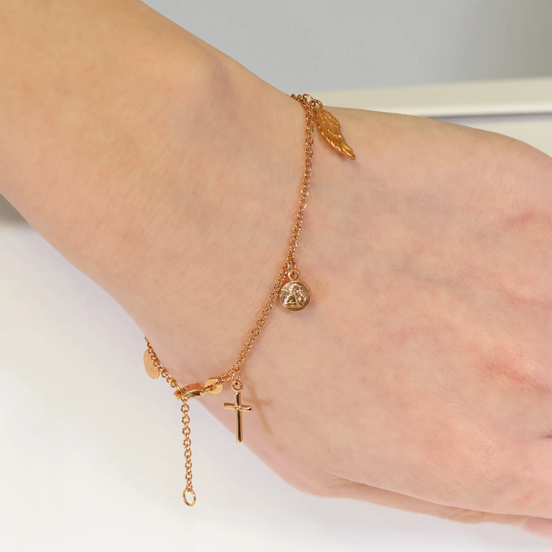 An 18ct rose gold bracelet featuring a chain link design with charms including a cross, a medallion, and a feather on the wrist