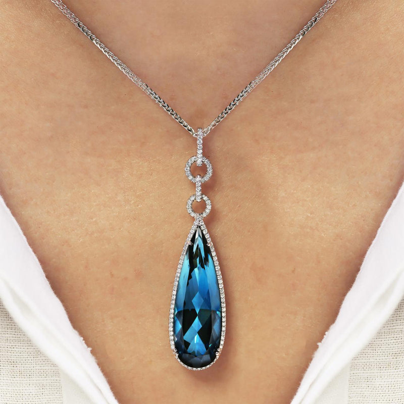 18ct white gold pear cut London blue topaz and diamond drop pendant on the neck