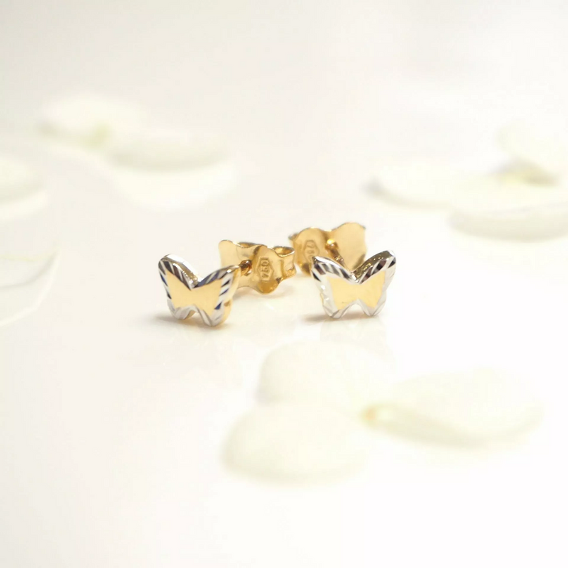 A pair of 18ct yellow and white gold butterfly stud earrings on a white background.