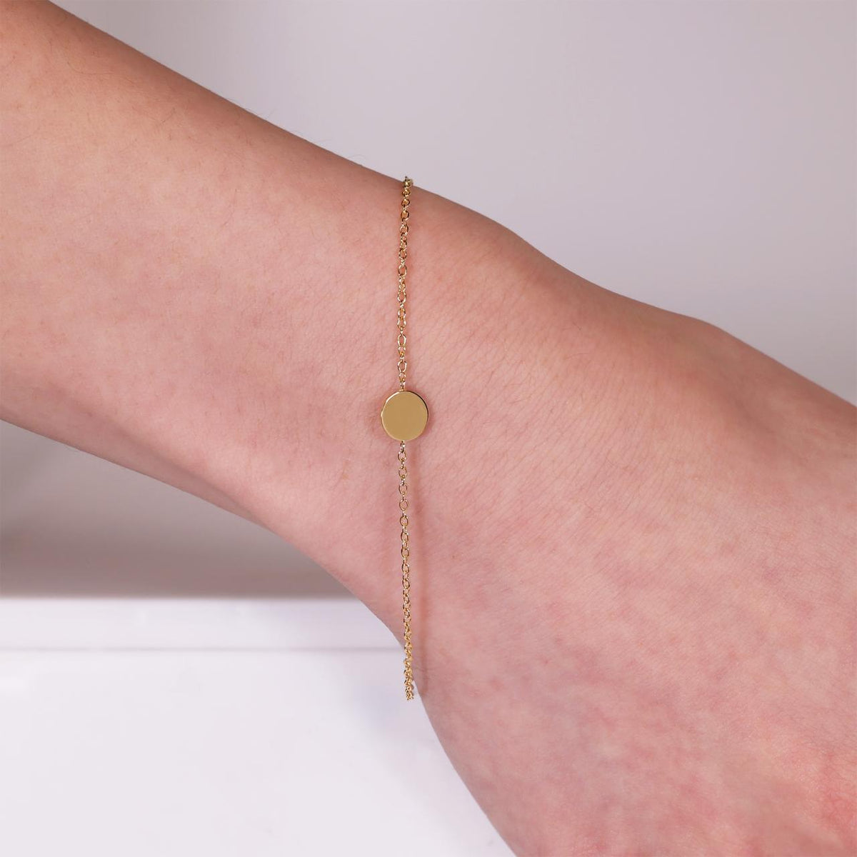 18ct yellow gold small disc bracelet on the wrist