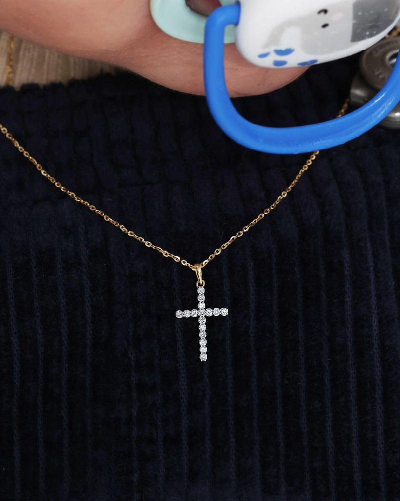 18ct yellow gold claw set 16=0.11ct diamond cross necklace on babies neck