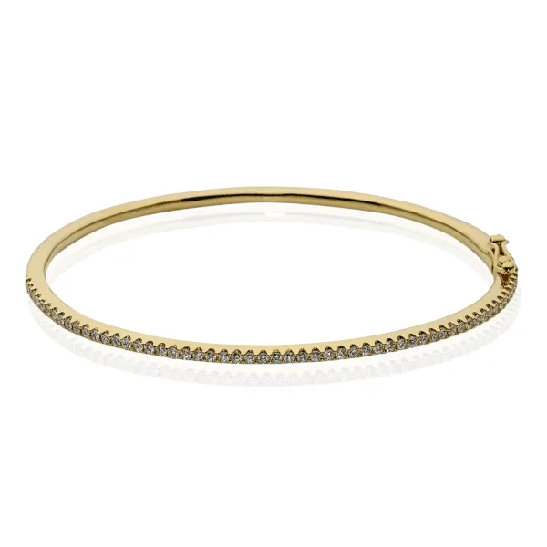 An 18ct yellow gold bangle featuring round brilliant cut diamonds.