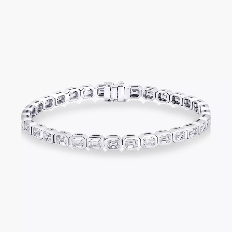 An 18ct white gold emerald cut diamond tennis bracelet with bezel setting
