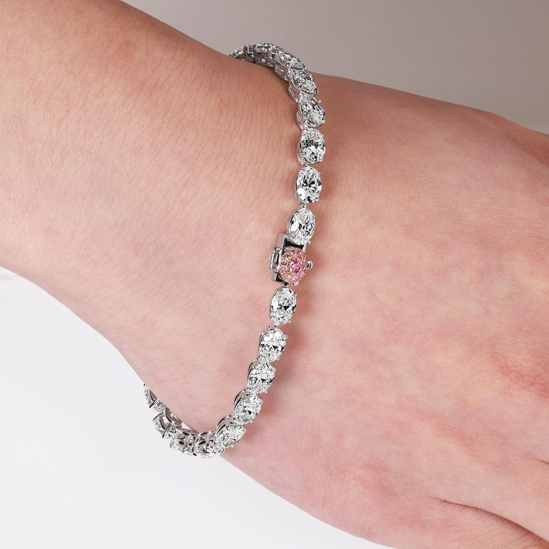 Platinum and rose gold 26=13.13ct oval white and Argyle Pink diamond diamond tennis bracelet on wrist
