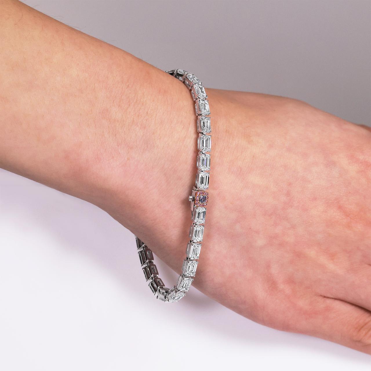 Platinum and 18ct rose gold emerald cut diamond tennis bracelet with certified pink and blue diamond clasp on wrist