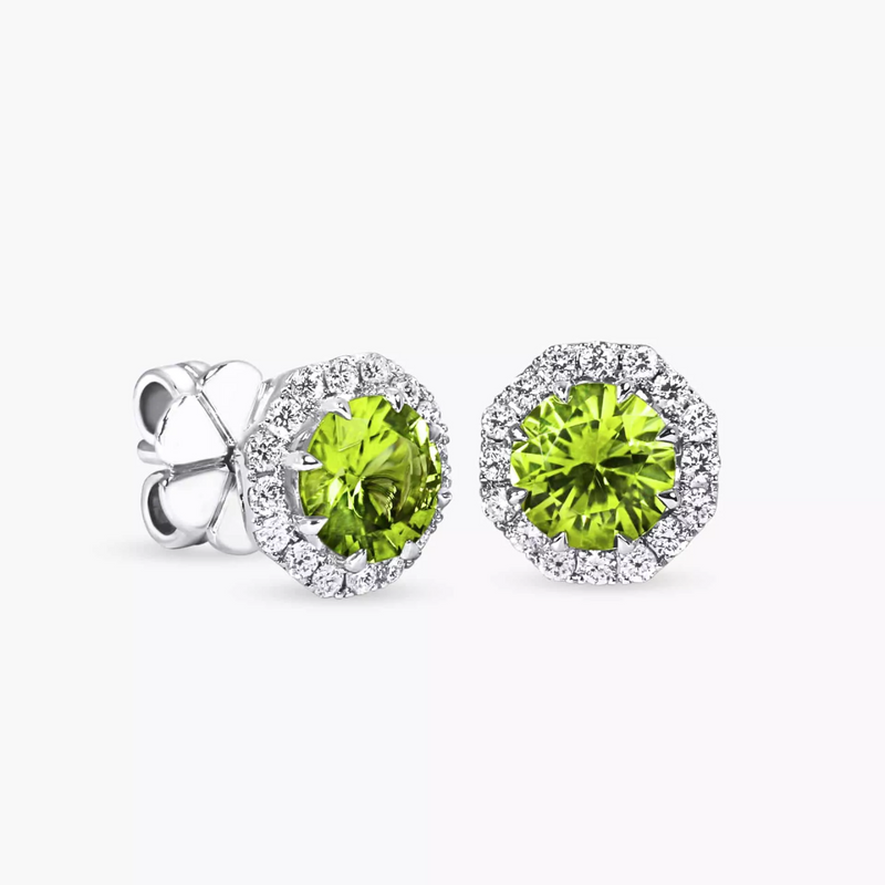 A pair of 18ct white gold peridot and diamond halo stud earrings with round briliant cut diamonds surrounding a larger peridot center stone.