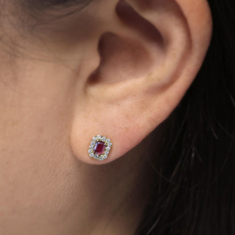 18ct yellow gold emerald cut ruby and round brilliant cut diamond halo stud earrings on the ear