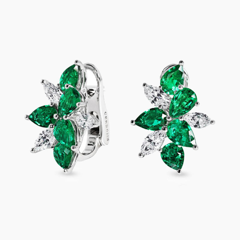 A pair of 18ct white gold earrings featuring pear shape emeralds and diamonds.