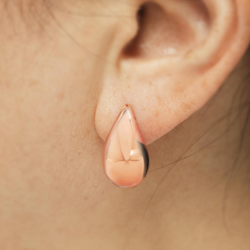 A pair of 18ct rose gold tear drop hollow earrings on the ear