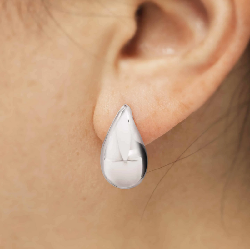 A pair of 18ct white gold tear drop hollow earrings on the ear