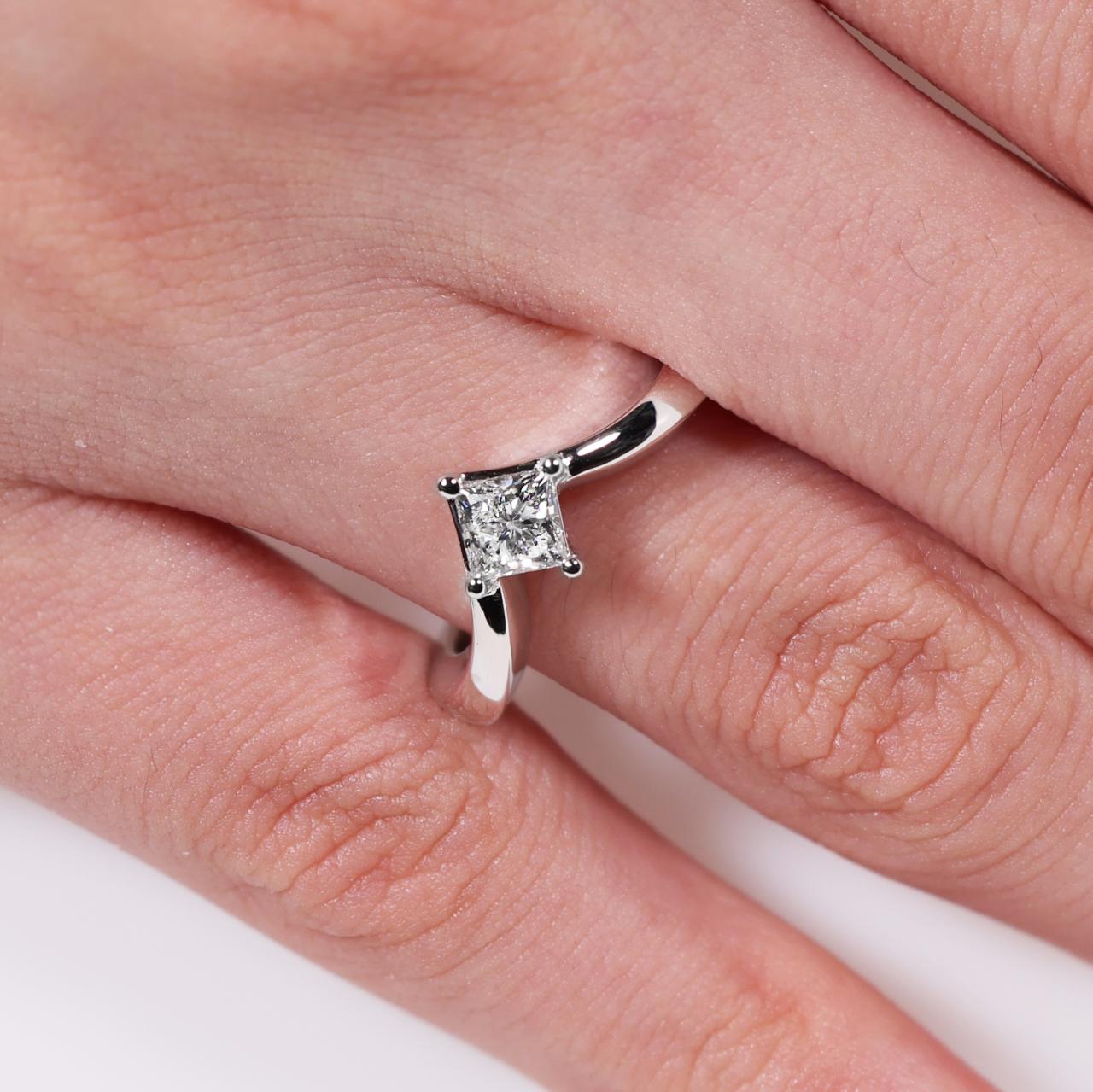 18ct white gold Princess cut diamond solitaire engagement ring in a four claw setting on the finger