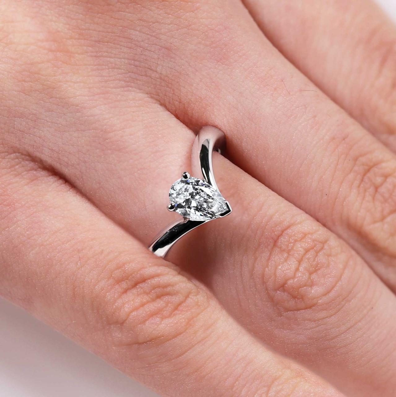 18ct white gold pear shaped lab grown diamond engagement ring on the finger