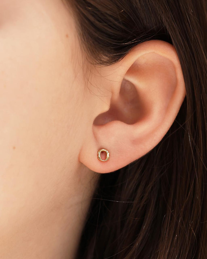 A pair of 18ct yellow gold small 'O' stud earrings from the Iconica Collection on the ear