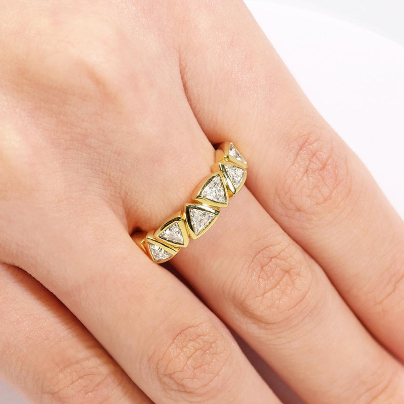 18ct yellow gold trilliant cut diamond bezel set ring on the finger