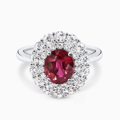 An 18ct white gold ring with an oval Mozambique ruby center stone and round brilliant cut diamond accents