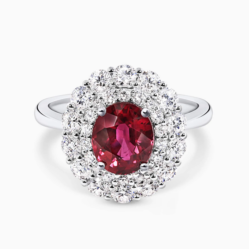 An 18ct white gold ring with an oval Mozambique ruby center stone and round brilliant cut diamond accents