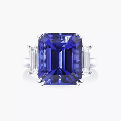 An 18ct white gold ring with an emerald cut Merelani tanzanite centerpiece and baguette diamonds in a claw setting on the sides.