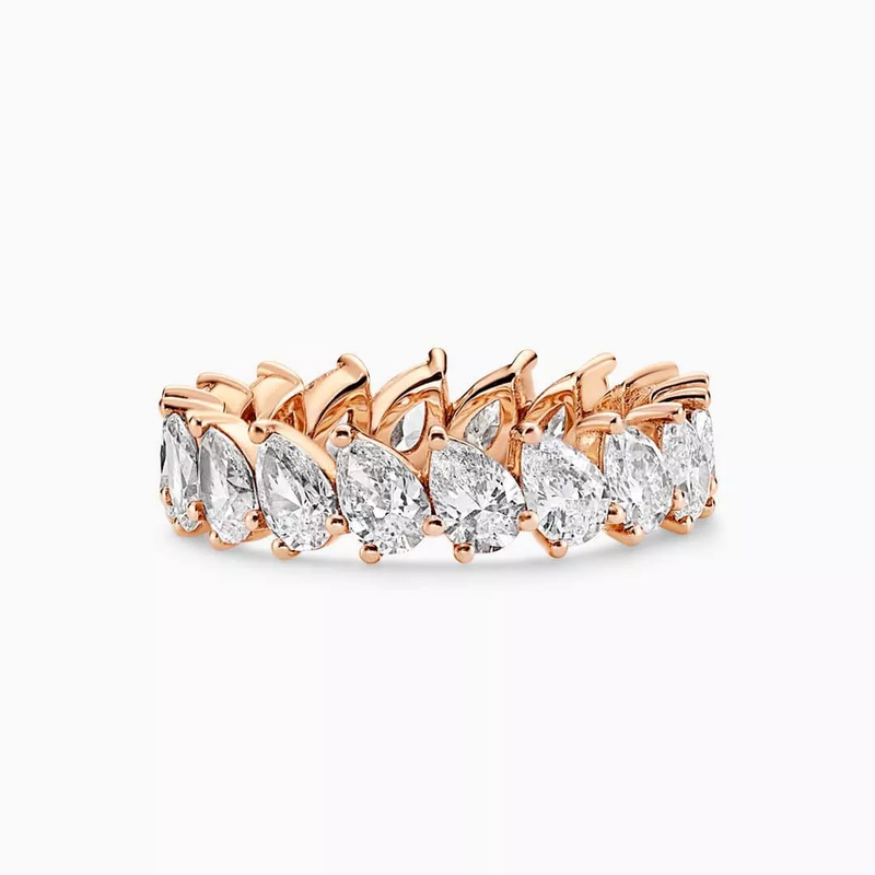 An 18ct rose gold ring with pear shaped diamond in a claw setting around the band.