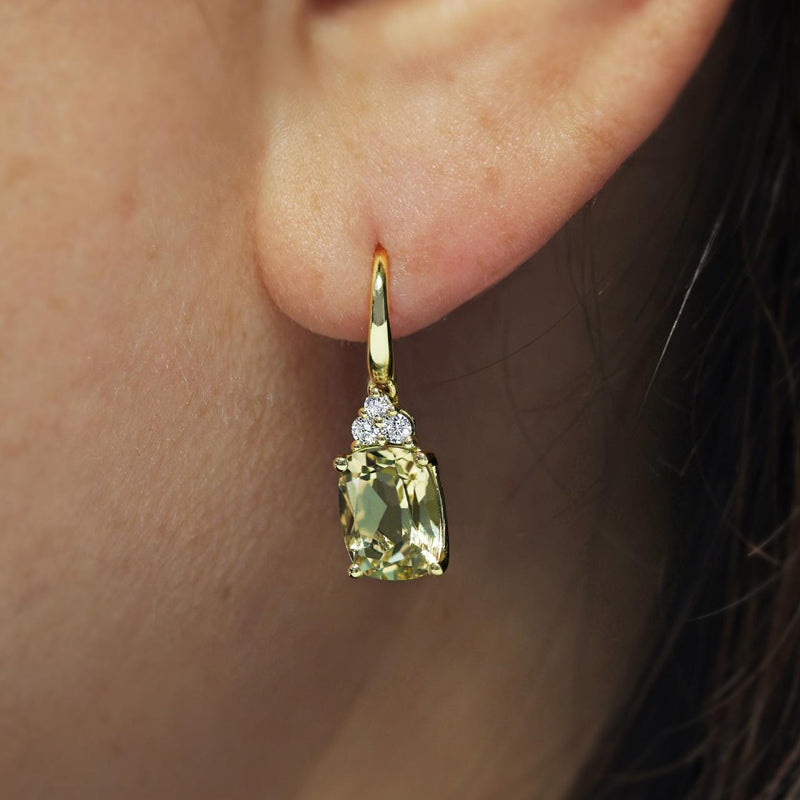 A pair of 18ct yellow gold hook earrings featuring cushion cut lemon quartz with round brilliant cut diamonds on the ear