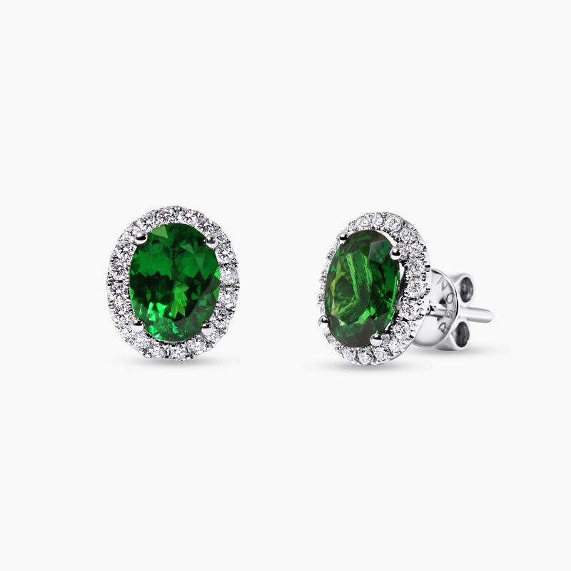 A pair of 18ct white gold oval tsavorite and round brilliant cut diamond halo stud earrings.
