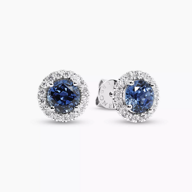 A pair of 18ct white gold round brilliant cut sapphire and diamond halo stud earrings.