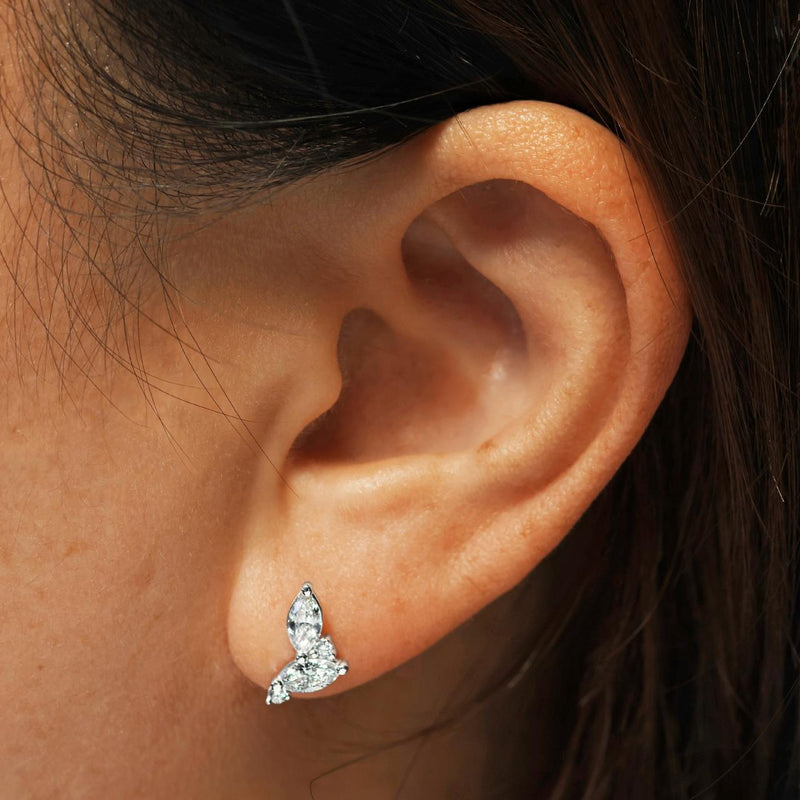 A pair of 18ct white gold marquise and round brilliant cut diamond stud earrings on the ear
