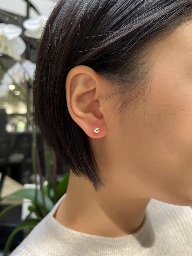 A pair of 18ct white gold diamond stud earrings with round brilliant cut diamonds in a four claw setting on the ear