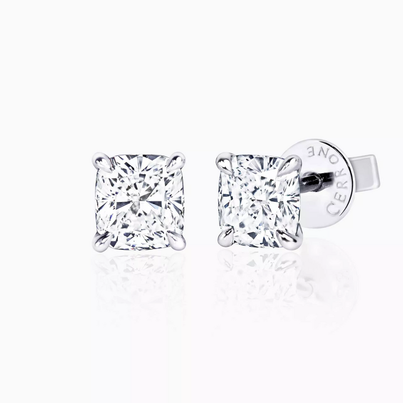 A pair of 18ct white gold cushion cut diamond stud earrings with a four claw setting.